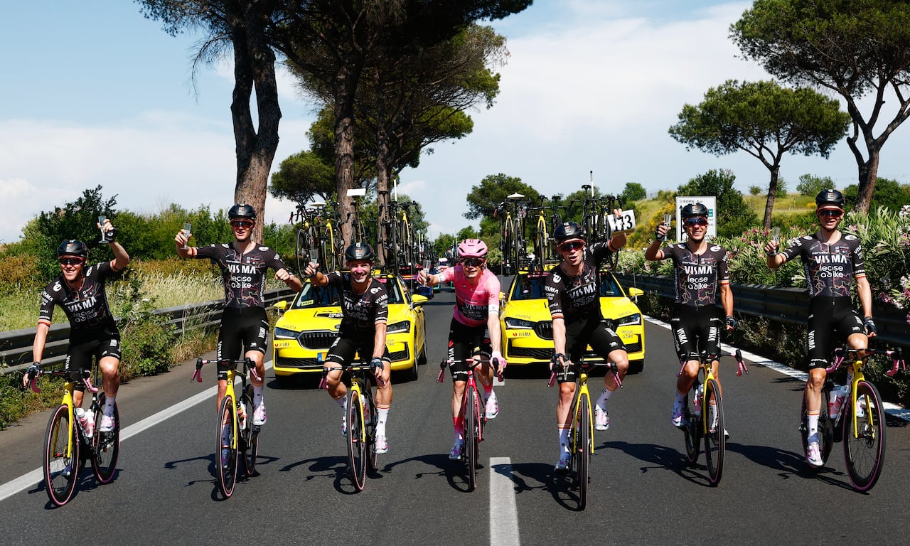 El ciclista danés Jonas Vingegaard, del equipo Visma Lease a Bike, con el maillot rosa de líder de la clasificación general, comparte una copa de vino espumoso con sus compañeros durante la 21ª etapa del Giro de Italia 2026, una carrera ciclista de 131 km que va de Roma a Roma, Italia, el 31 de mayo de 2026. (Foto de Luca Bettini / AFP)