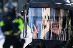 Minnesota Department of Natural Resources Conservation Officers stand guard as demonstrators gather near the site of where state and local authorities say a man was shot and killed by federal agents earlier in the morning in Minneapolis, Minnesota, on January 24, 2026. Federal immigration agents shot dead a man in Minneapolis on Saturday, officials said -- the second fatal shooting of a civilian in the city, sparking fresh protests and outrage from state officials. The death came less than three weeks after US citizen Renee Good was shot and killed by an Immigration and Customs Enforcement officer involved in sweeps to round up undocumented migrants. (Photo by ROBERTO SCHMIDT / AFP)