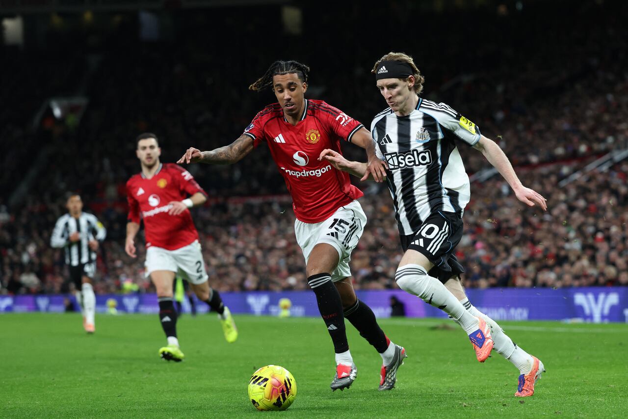 El centrocampista inglés #10 del Newcastle United, Anthony Gordon (der.), compite con el defensa francés #15 del Manchester United, Leny Yoro (centro), durante el partido de la Premier League inglesa entre el Manchester United y el Newcastle United en Old Trafford, en Manchester, noroeste de Inglaterra, el 26 de diciembre de 2025. (Foto de Darren Staples / AFP)