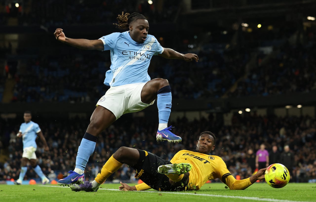 El centrocampista belga #11 del Manchester City, Jeremy Doku (izq.), es tackleado por el defensa colombiano #15 del Wolverhampton Wanderers, Yerson Mosquera, durante el partido de la Premier League inglesa entre el Manchester City y el Wolverhampton Wanderers en el Etihad Stadium en Manchester, noroeste de Inglaterra, el 24 de enero de 2026. (Foto de Darren Staples / AFP)