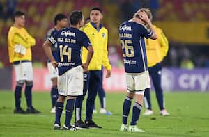 Millonarios' midfielder David Silva (14) and defender Andres Llinas (R) react after the Copa Libertadores group stage second leg football match between Colombia's Millonarios and Bolivia's Bolivar at the Nemesio Camacho "El Campin" stadium in Bogota on May 8, 2024. (Photo by Raul ARBOLEDA / AFP)