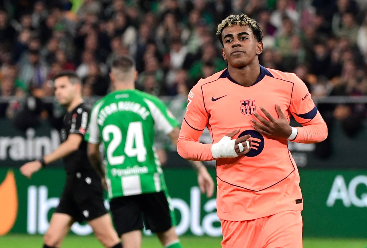 El delantero español #10 del Barcelona, Lamine Yamal, celebra el quinto gol de su equipo desde el punto de penalti durante el partido de la liga española entre el Real Betis y el FC Barcelona en el Estadio Benito Villamarín en Sevilla el 6 de diciembre de 2025. (Foto de CRISTINA QUICLER / AFP)