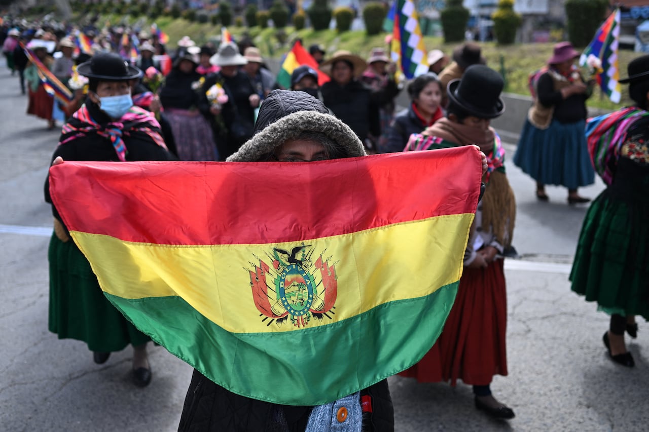 An Indigenous woman holds a Bolivian flag during a protest against the government of President Rodrigo Paz on Mother's Day in La Paz on May 27, 2026. (Photo by Marvin RECINOS / AFP)