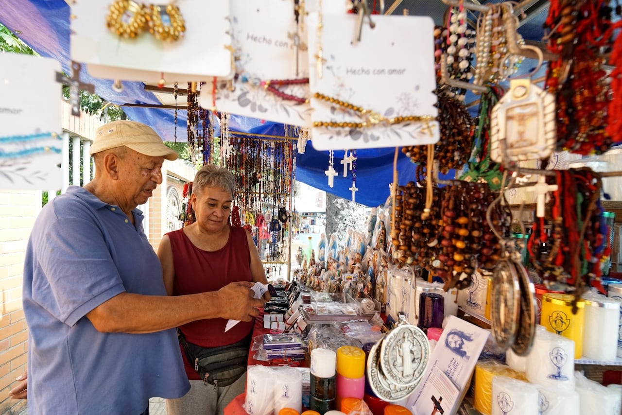 A las afueras del santuario de La Milagrosa, los puestos de artículos religiosos se alinean como una extensión de la fe popular en Cali.
Allí, entre velas y escapularios, decenas de familias han construido su sustento durante más de cuatro décadas. Foto Jorge Orozco