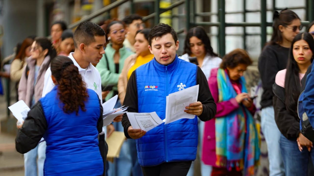 Un funcionario del Sena en compañía de personas que buscan empleo, en Bogotá
