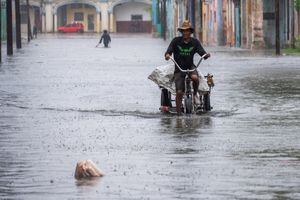 Un hombre pasea en triciclo por una calle inundada en La Habana, el 29 de agosto de 2023, durante el paso de la tormenta tropical Idalia. (Photo by YAMIL LAGE / AFP)