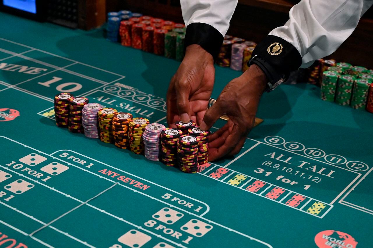 Un crupier de dados prepara montones de fichas de casino en el Caesars Palace en el Strip de Las Vegas, listos para jugar.
