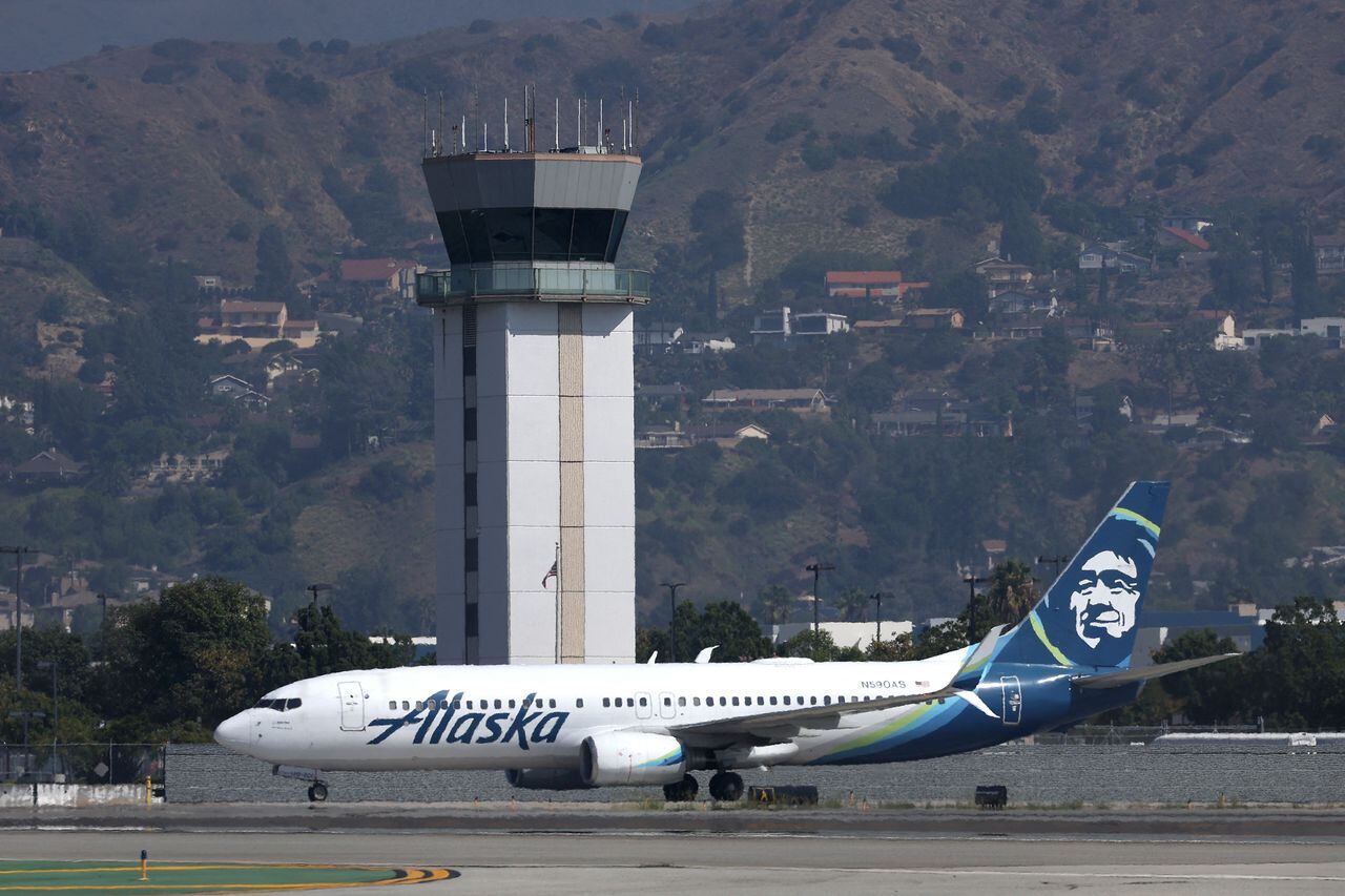 La torre de control del aeropuerto Hollywood Burbank se encuentra sobre un avión de Alaska Airlines mientras rueda el 25 de septiembre de 2023 en Burbank, California.
