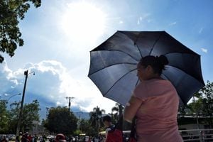 Una mujer se cubre del intenso sol que esta semana elevó la temperatura hasta 35 grados en Cali. (Foto: Ricardo Ortegón)