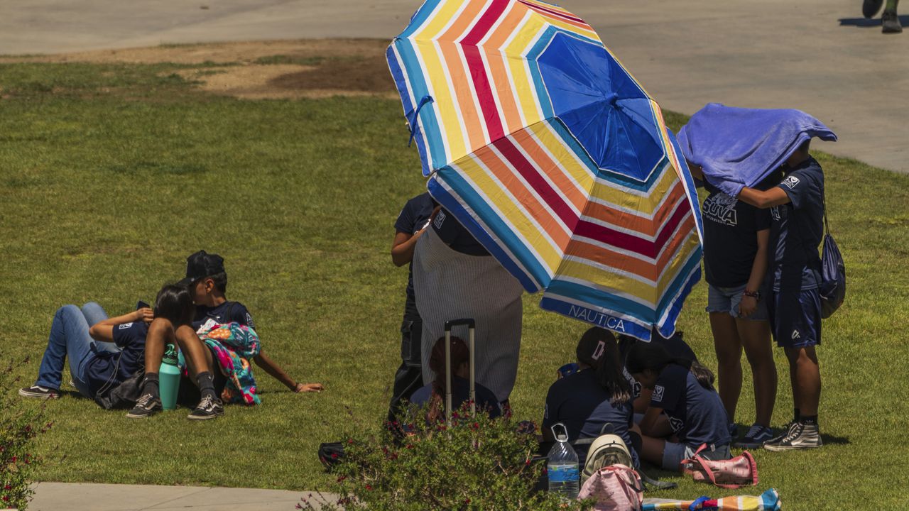 Los estudiantes intentan protegerse de la luz del sol en los jardines del Observatorio Griffith en Los Ángeles el viernes 14 de julio de 2023. Más de un tercio de los estadounidenses están bajo avisos, alertas y advertencias de calor extremo a medida que continúa una ola de calor abrasadora en el suroeste y California.