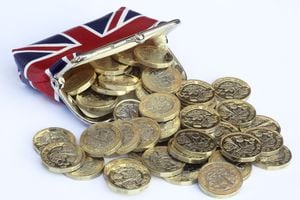 Monedas de una libra recién acuñadas saliendo del bolso con un diseño de Reino Unido.
