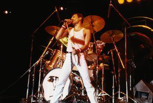 Freddie Mercury (1946-1991), cantante de Queen, de pie frente a una batería mientras canta frente a un micrófono en el escenario durante un concierto en vivo de la banda en el National Bowl de Milton Keynes, Inglaterra, Reino Unido, el 5 de junio. 1982. (Foto de Fox Photos/Hulton Archive/Getty Images)