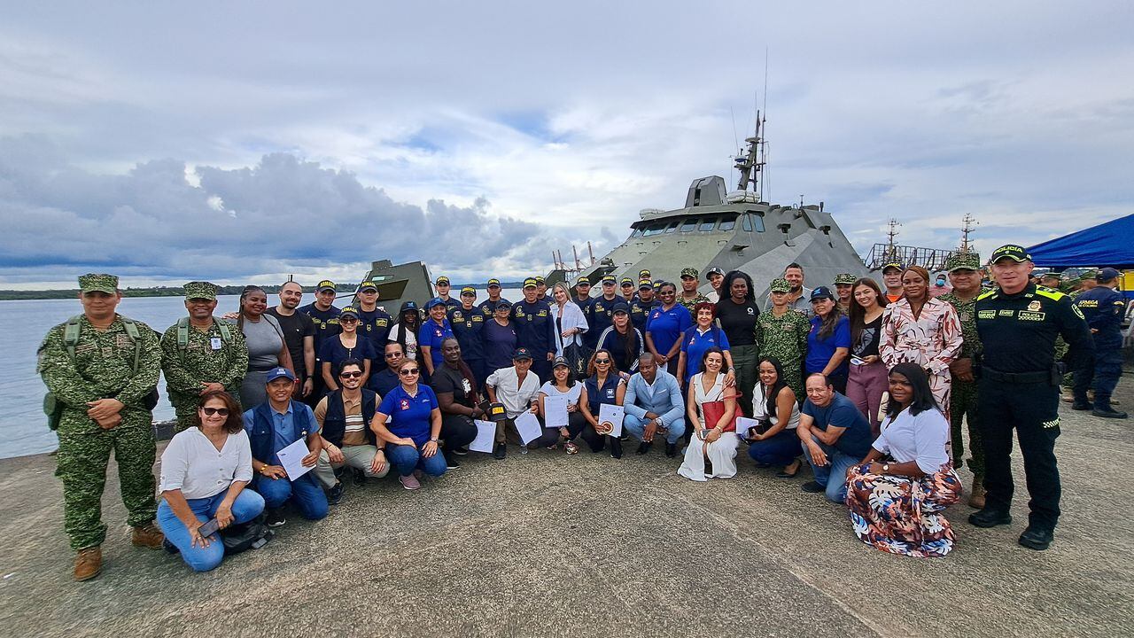La delegación de especialistas de la salud y fundaciones que viajaron a Puerto Merizalde con la Armada. Atrás, el buque Jorge Moreno Salazar.