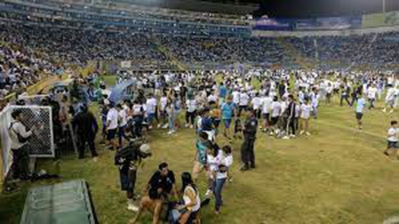 Los simpatizantes son ayudados por otros luego de una estampida durante un partido de fútbol entre Alianza y FAS en el estadio Cuscatlán en San Salvador.