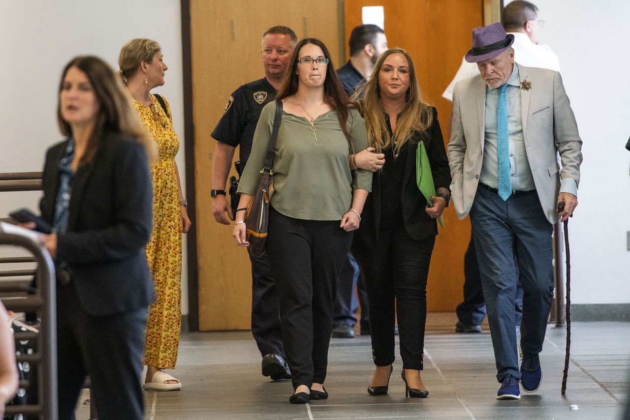 El abogado John Ray, a la derecha, y Jasmine Robinson, al centro a la izquierda, prima de Jessica Taylor, víctima del asesino en serie de Long Island, salen de la sala del tribunal en el complejo judicial Arthur M. Cromarty, el viernes 14 de julio de 2023