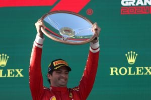 Con una sonrisa, así festejó Carlos Sainz su victoria en el GP de Australia de Fórmula 1 2024, quien exhibe el trofeo recibido por ser el ganador del circuito. /Foto Martin KEEP / AFP) -