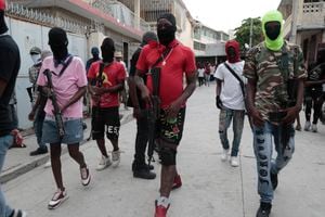 Miembros armados de la pandilla "G9 y Familia" participan en una marcha contra el primer ministro de Haití, Ariel Henry, en Puerto Príncipe, Haití, el 19 de septiembre de 2023. (AP Foto/Odelyn Joseph)