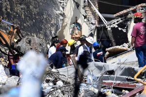 Rescatistas y miembros de Protección Civil retiran una bolsa entre los escombros después de que el techo de una iglesia se derrumbara durante un bautismo en Ciudad Madero, estado de Tamapulipas, México, el 2 de octubre de 2023.