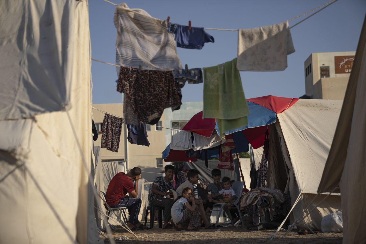 Palestinos desplazados por los ataques israelíes contra la Franja de Gaza sentados en un campamento del Programa de las Naciones Unidas para el Desarrollo en Jan Yunis, el 19 de octubre de 2023. (AP Foto/Fatima Shbair)