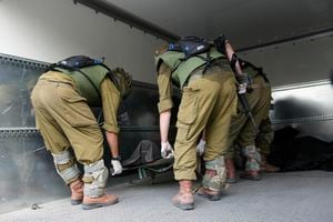 Israeli soldiers load bodies of killed Israelis in kibbutz Kfar Azza on Tuesday, Oct. 10, 2023. Hamas militants overran Kfar Azza on Saturday, where many Israelis were killed and taken captive. (AP Photo/Ohad Zwigenberg)